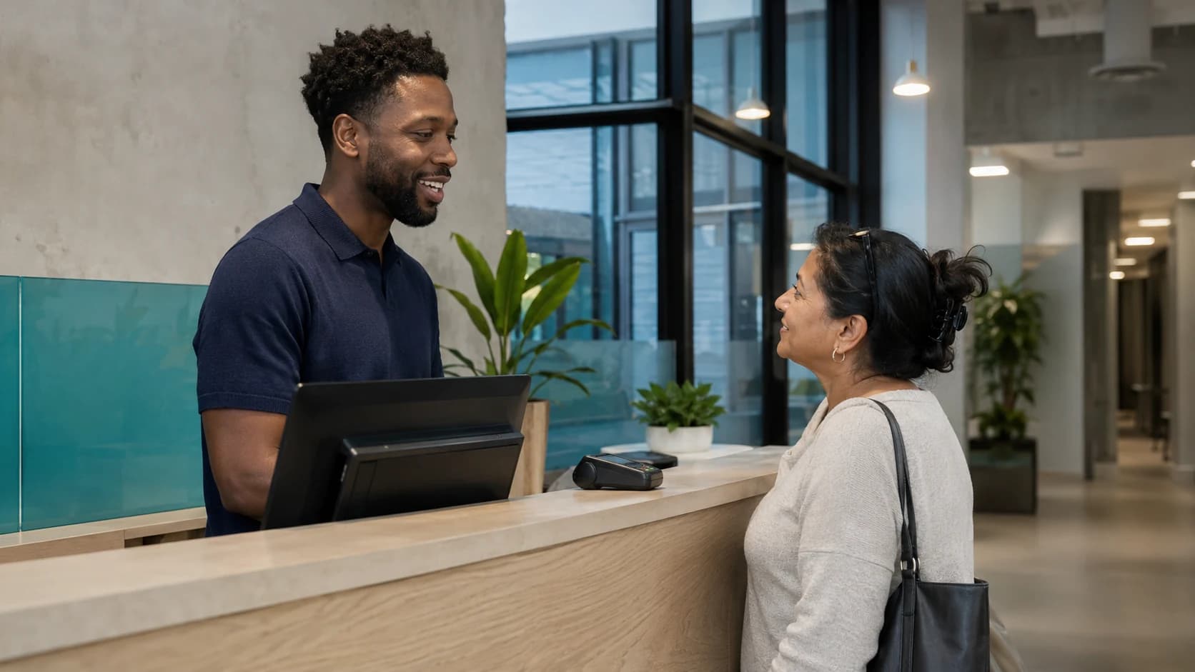 Clinic front desk staff checking in a patient